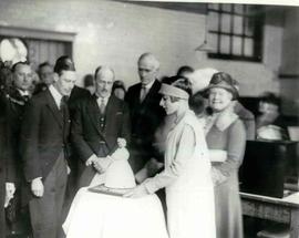 Duke of York receiving a cake in the shape of a girl wearing a crinoline for Princess Elizabeth